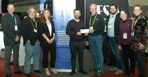 Westview president Eric Bloom presents a cheque to Eddie Raymond, surrounded by Westview team members and BTS board members